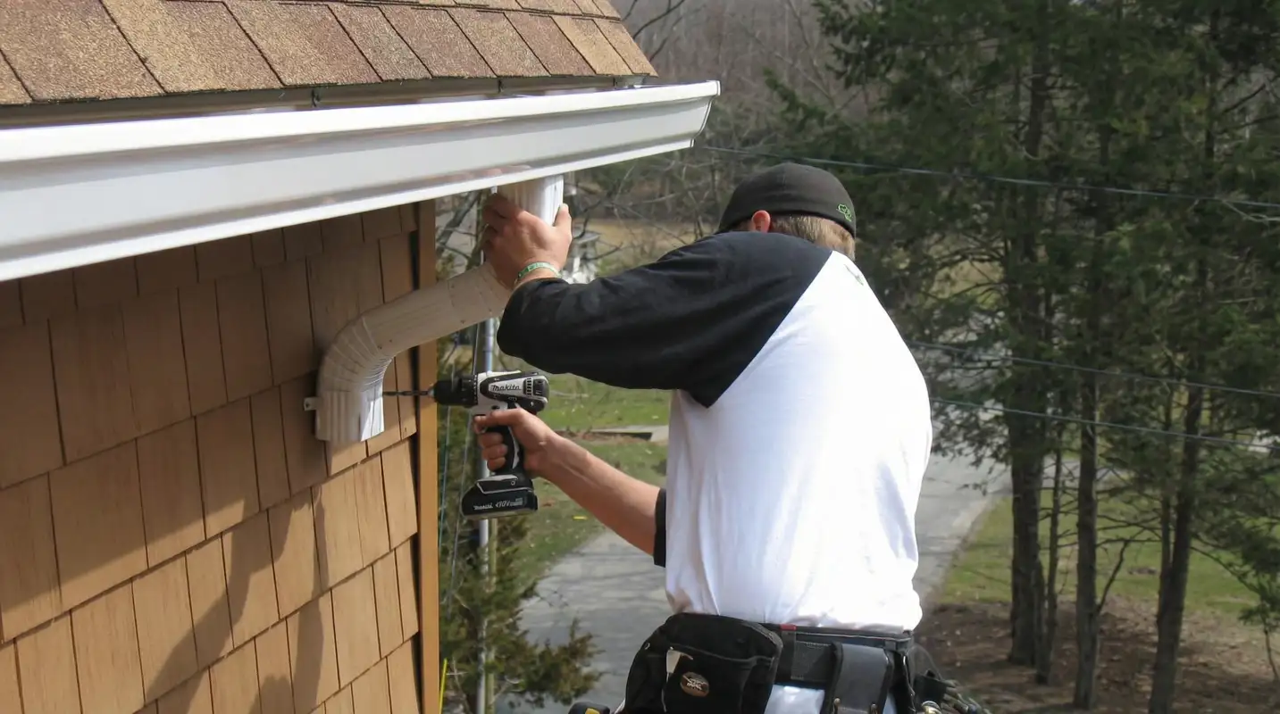Professional contractor installing tan vinyl siding panels on a residential home exterior in Honolulu, HI